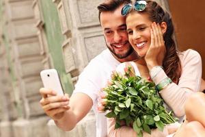 jovem casal romântico usando smartphone na cidade foto