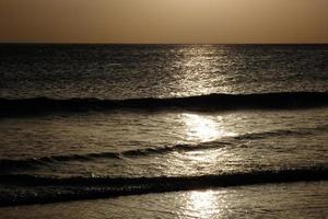 pôr do sol sobre o mar, pôr do sol no outono na praia de zahara de los atunes, cádiz, andaluzia, espanha foto