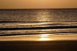pôr do sol sobre o mar, pôr do sol no outono na praia de zahara de los atunes, cádiz, andaluzia, espanha foto