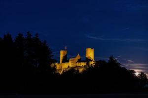 imagem da ruína iluminada do castelo muenzenberg na alemanha à noite foto