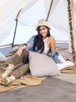 retrato linda jovem mulher asiática muito sorriso uma pessoa sozinha sentada na cadeira acampar com flor teble em vaso lanterna vermelho viagem viagem na frente barraca liberdade relaxar feliz desfrutar nas férias foto