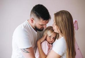 feliz família multinacional pai jovem e mãe com filha pequena se divertindo no quarto das crianças em casa foto