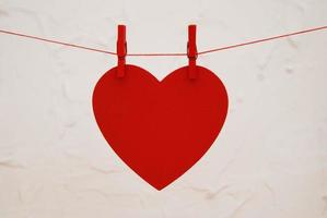 coração vermelho pendurado no varal em fundo branco com espaço. dia dos Namorados. foto