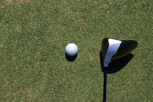 feche o clube de golfe e a bola na grama. foto