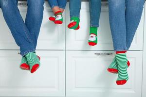 o conceito de uma família feliz vestida com meias de natal na cozinha foto