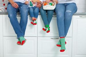 o conceito de uma família feliz vestida com meias de natal na cozinha foto