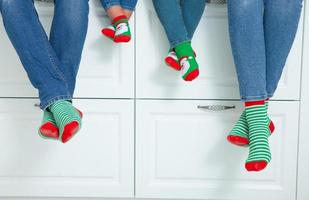 o conceito de uma família feliz vestida com meias de natal na cozinha foto