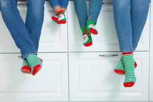 o conceito de uma família feliz vestida com meias de natal na cozinha foto