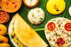 sul da Índia masala dosa, uttapam, idli vada sambar, semolina halwa, upma servido sobre folha de bananeira foto