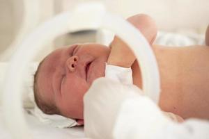 um bebê recém-nascido encontra-se em caixas no hospital. uma criança em uma incubadora. Unidade de Terapia Intensiva Neonatal e Prematuro foto