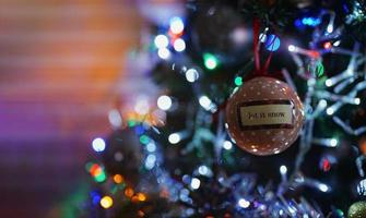 bugiganga de enfeites de natal na árvore com fundo claro embaçado, bola de natal nos ramos de abeto, banner horizontal para feliz natal, cartão de feliz ano novo, noel, conceito de férias de inverno foto