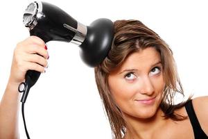 mulher jovem e um secador de cabelo foto