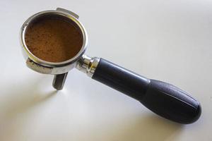 porta filtro com café moído e grão de café isolado de um fundo branco foto