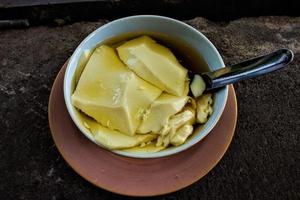 wedang tahu ou kembang tahu é uma bebida de gengibre e contém tofu tofu feito de suco de soja e xarope de açúcar de palma. Pudim de tofu tradicional foto