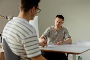 homem profissional sério que consulta o cliente no escritório. dois homens se encontrando, conversando sobre negócios. seguradora dando conselhos, gerente fazendo oferta. estagiário de ensino de mentor. entrevista de emprego. foto