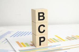 bcp, planejamento de continuidade de negócios, palavra em blocos de madeira e gráficos foto