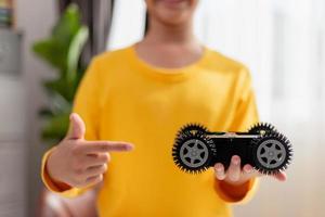 os alunos da ásia aprendem em casa na codificação de carros robóticos e cabos de placa eletrônica em haste, vapor, código de computador de tecnologia de ciência de engenharia matemática em robótica para o conceito de crianças. foto