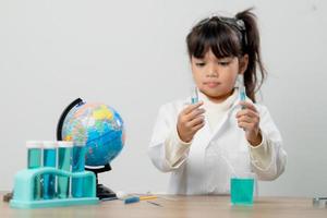 educação, ciência, química e conceito de crianças - crianças ou estudantes com tubo de ensaio fazendo experimento no laboratório da escola foto