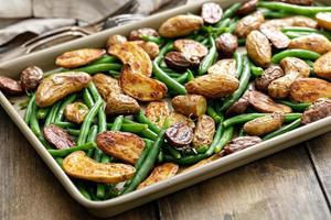 batatas de alevinos crocantes assadas com feijão verde em uma assadeira foto