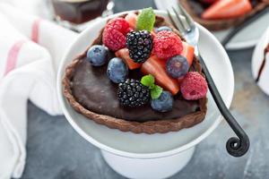 Tortas de coração de chocolate com recheio de ganashe e frutas vermelhas foto