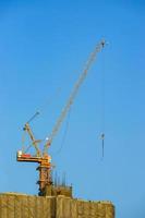 guindaste de construção está trabalhando construindo no céu azul. foto