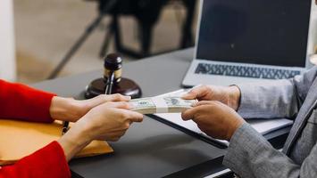 conceito de justiça e direito. juiz masculino em um tribunal com o martelo, trabalhando com, computador e teclado de encaixe, óculos, na mesa na luz da manhã foto