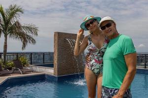 casal em uma piscina na cobertura aproveitando o dia e a vista foto