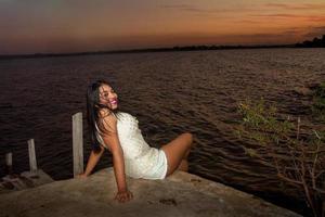 linda jovem brasileira com um lindo sorriso no parque ao pôr do sol foto