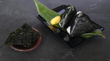 onigiri é comida japonesa, bolinho de arroz japonês, triângulo de arroz com algas marinhas, nori isolado com fundo foto