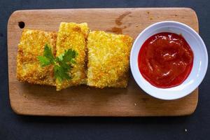 risoles fritos ou risol mayo são petiscos indonésios. como coxinha de galinha. servido com molho de pimenta, aipo em tábua de madeira foto