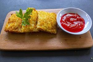 risoles fritos ou risol mayo são petiscos indonésios. como coxinha de galinha. servido com molho de pimenta, aipo em tábua de madeira foto