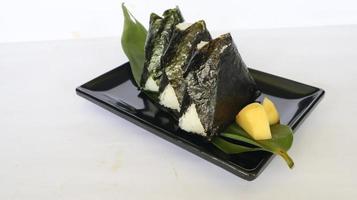 onigiri é comida japonesa, bolinho de arroz japonês, triângulo de arroz com algas marinhas, nori isolado com fundo foto