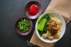 mie ayam ou noodles frango é comida tradicional da indonésia, ásia feita de macarrão, frango, caldo de galinha, espinafre, às vezes com almôndega. foto