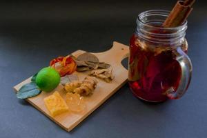 wedang uwuh é uma bebida tradicional à base de ervas da Indonésia. feito de folhas de canela, noz-moscada e cravo. outro ingrediente é a madeira da árvore secang, gengibre e torrões de açúcar em fundo preto foto