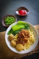 mie ayam ou noodles frango é comida tradicional da indonésia, ásia feita de macarrão, frango, caldo de galinha, espinafre, às vezes com almôndega. foto