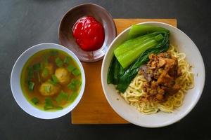 mie ayam ou noodles frango é comida tradicional da indonésia, ásia feita de macarrão, frango, caldo de galinha, espinafre, às vezes com almôndega. foto