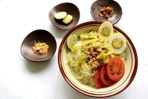 soto lamongan é um prato de sopa lamongan, leste de java, indonésia. feito de frango, aletria, ovo, broto de feijão, açafrão, o caldo e koya foto