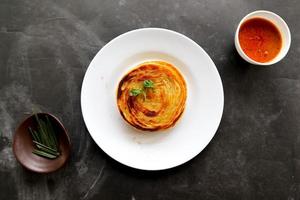 pão paratha ou pão canai ou roti maryam, prato favorito do café da manhã. servido no prato foto