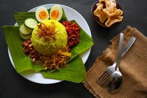 nasi kuning ou arroz amarelo ou tumeric rice é um alimento tradicional da Ásia, feito de arroz cozido com açafrão, leite de coco r foto