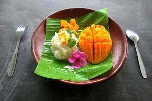 arroz pegajoso de manga é uma sobremesa tailandesa feita de arroz pegajoso, manga e leite de coco. foto
