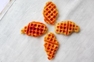 croissant waffle ou croffle com calda de chocolate servido em caixa e fundo branco foto