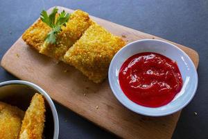 risoles fritos ou risol mayo são petiscos indonésios. como coxinha de galinha. servido com molho de pimenta, aipo em tábua de madeira foto