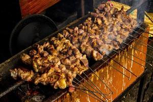 sate klatak ou sate kambing ou satay cabra, cordeiro, cordeiro ou carne de cabra satay com ingrediente de carvão em fogo vermelho grelhando por pessoas, indonésia cozinhando satay. com foco seletivo foto