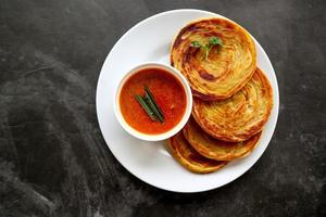 pão paratha ou pão canai ou roti maryam, prato favorito do café da manhã. servido no prato foto