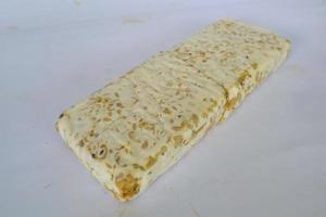 tempeh cru ou tempe. fatias de tempeh em fundo branco. sementes de soja crua. tempe é um alimento tradicional indonésio feito de soja fermentada. foto