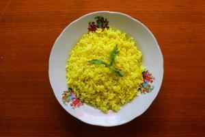 arroz amarelo ou arroz de açafrão ou nasi kuning é um alimento feito de arroz cozido com açafrão, leite de coco e especiarias. assim o sabor fica mais salgado foto