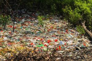 lixo plástico derramado na terra da cidade grande. garrafas plásticas sujas usadas vazias. poluição plástica. poluição ambiental. problema ecológico. foto