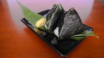 onigiri é comida japonesa, bolinho de arroz japonês, triângulo de arroz com algas marinhas, nori isolado com fundo foto