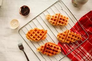 croissant waffle ou croffle com calda de chocolate servido em caixa e fundo branco foto