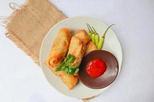 lumpia ou lunpia, é um lanche tradicional de rolinho primavera de semarang, indonésia. rolinhos primavera tradicionais feitos de ovos e frango ou camarão, brotos de bambu fritos. isolado no fundo branco foto